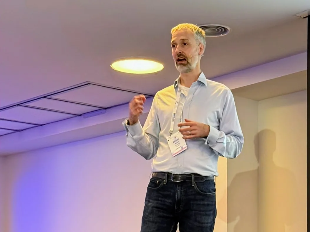 Rufus Curnow delivering a lecture on stage at the EFCLIN Congress in Barcelona